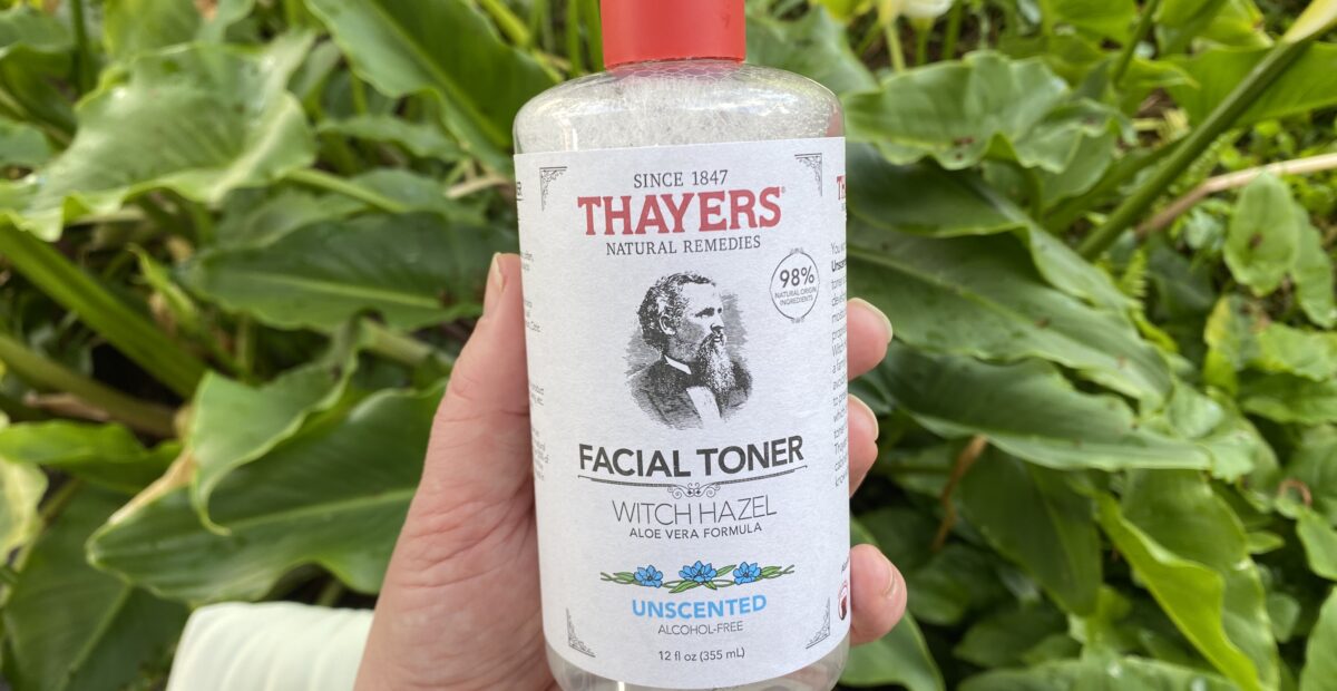 Picture of Thayers toner being held with green plants in the background