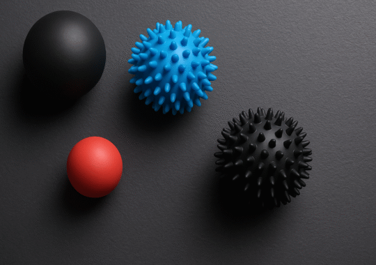 Picture of 4 massage balls against a black background