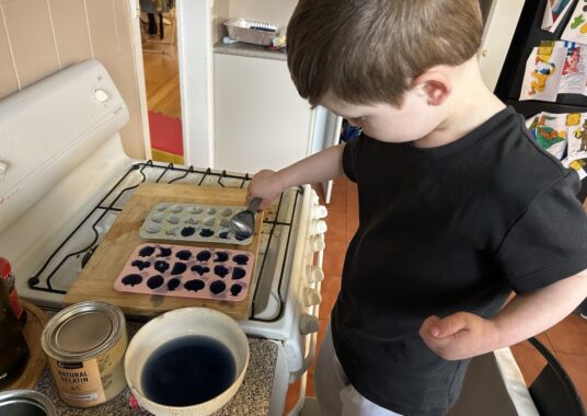 Picture of a toddler making gummies from Nutra Organics gelatin